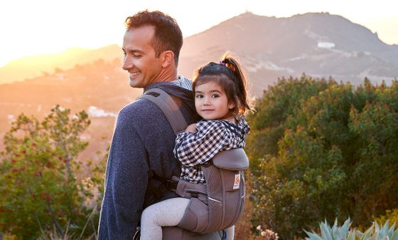 Vatertag- Papa trägt ein Baby in Ergobaby Babytrage